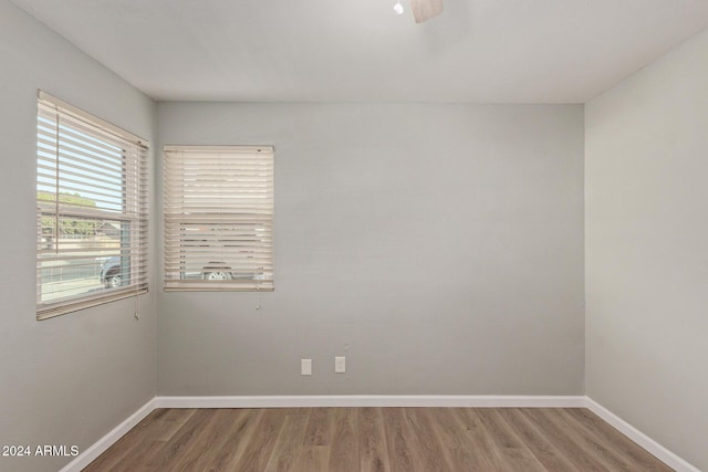 spare room featuring baseboards and wood finished floors