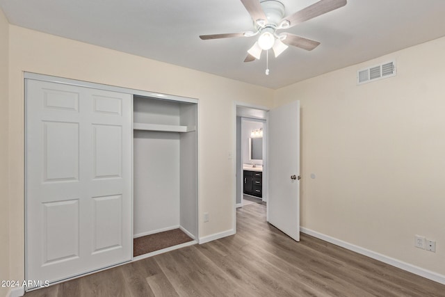 unfurnished bedroom featuring a closet, visible vents, a ceiling fan, wood finished floors, and baseboards