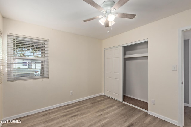 unfurnished bedroom with a ceiling fan, a closet, baseboards, and wood finished floors