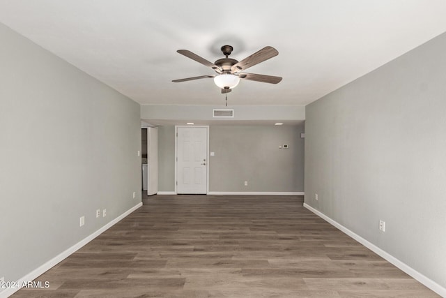 empty room with visible vents, ceiling fan, baseboards, and wood finished floors