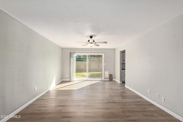 unfurnished living room with ceiling fan, baseboards, and wood finished floors