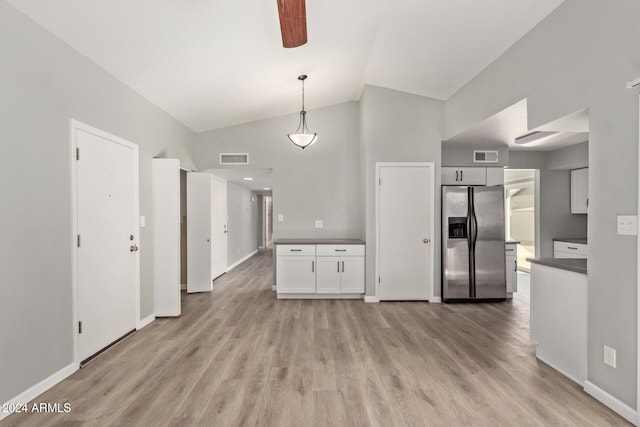 kitchen with light wood finished floors, stainless steel fridge, visible vents, lofted ceiling, and white cabinetry