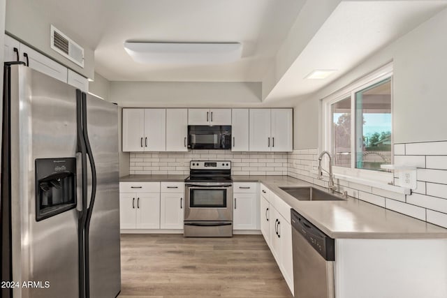 kitchen featuring visible vents, appliances with stainless steel finishes, white cabinets, and a sink