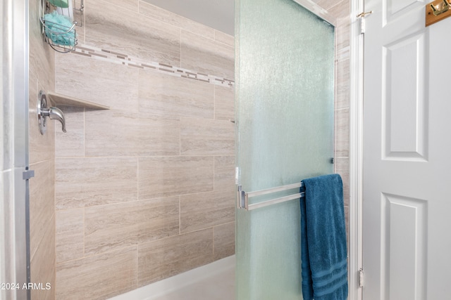 bathroom featuring a shower with shower door