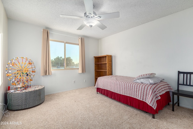 carpeted bedroom featuring ceiling fan and a textured ceiling