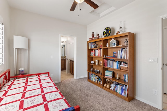 carpeted bedroom with ceiling fan, ensuite bath, and baseboards