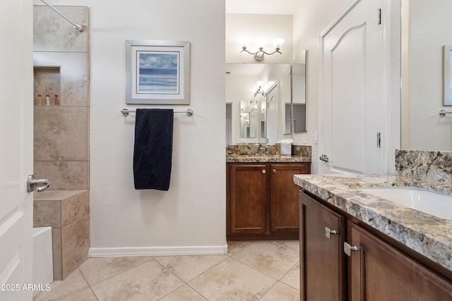 bathroom with a sink, a shower, two vanities, and tile patterned floors