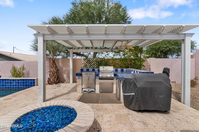 view of patio / terrace featuring a fenced backyard, a pergola, exterior kitchen, and area for grilling