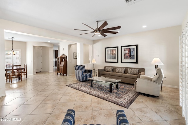 living area with light tile patterned floors, visible vents, and baseboards