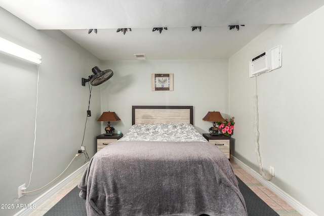 bedroom with a wall mounted air conditioner and light tile patterned floors