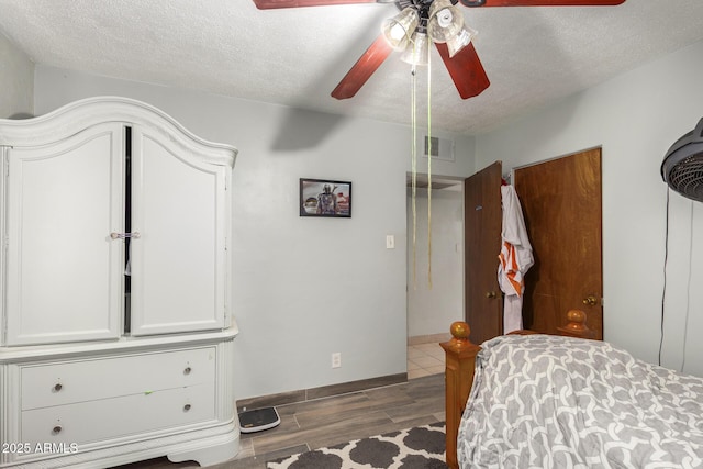 bedroom with ceiling fan and a textured ceiling