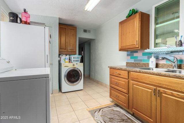 laundry area with sink, light tile patterned floors, and cabinets