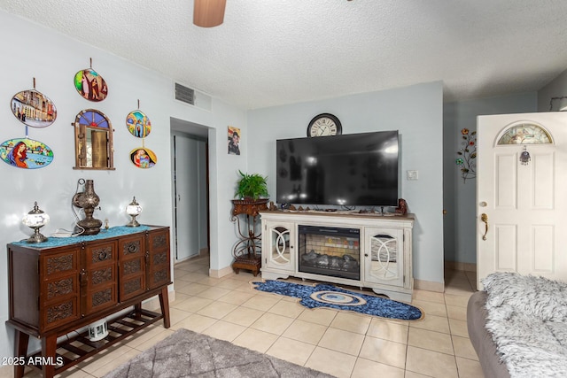 tiled living room featuring a textured ceiling and ceiling fan