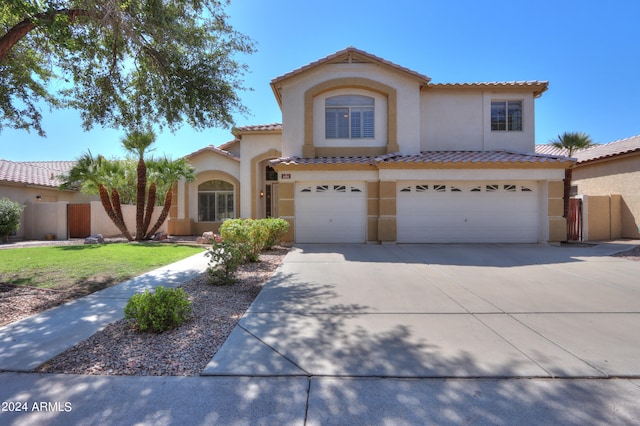 mediterranean / spanish house featuring a garage and a front lawn