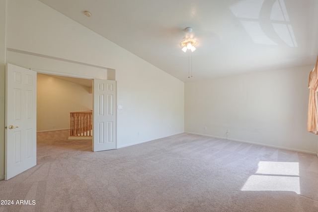 carpeted empty room with vaulted ceiling