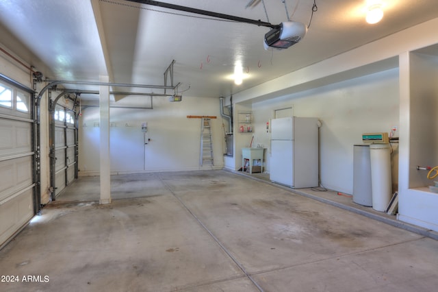 garage with white fridge and a garage door opener