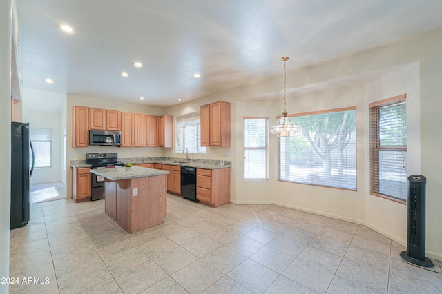 kitchen featuring black appliances, a center island, plenty of natural light, and pendant lighting