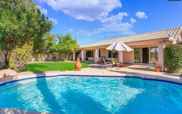 rear view of property featuring a patio and a lawn