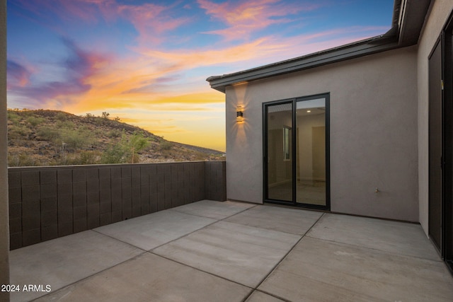 patio terrace at dusk featuring a mountain view