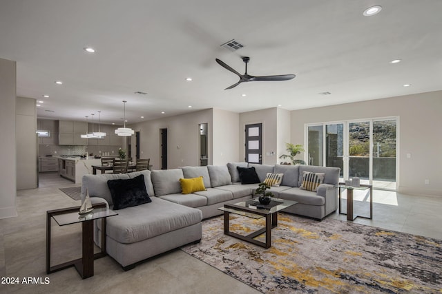 living area with a ceiling fan, recessed lighting, and visible vents