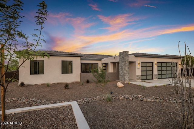 view of front of house featuring driveway, an attached garage, and stucco siding