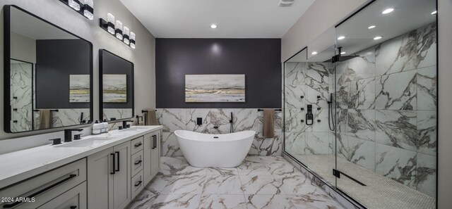 full bath featuring marble finish floor, a marble finish shower, recessed lighting, a freestanding bath, and a sink