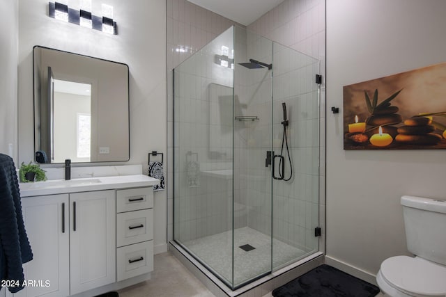 full bathroom featuring vanity, a shower stall, toilet, and baseboards