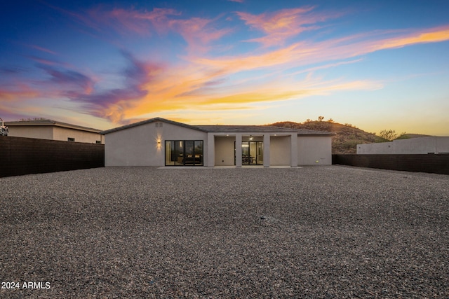 view of front of house with a fenced backyard, a patio, and stucco siding