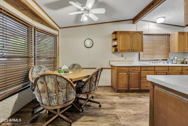 17124 E Fairway Dr, Mayer, AZ 86333 - kitchen with ornamental molding, light wood-style floors, light countertops, wallpapered walls, and brown cabinets