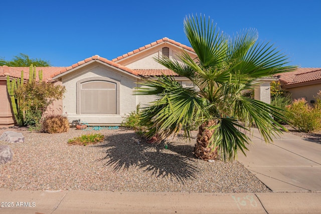 mediterranean / spanish-style house with stucco siding, driveway, and a tile roof