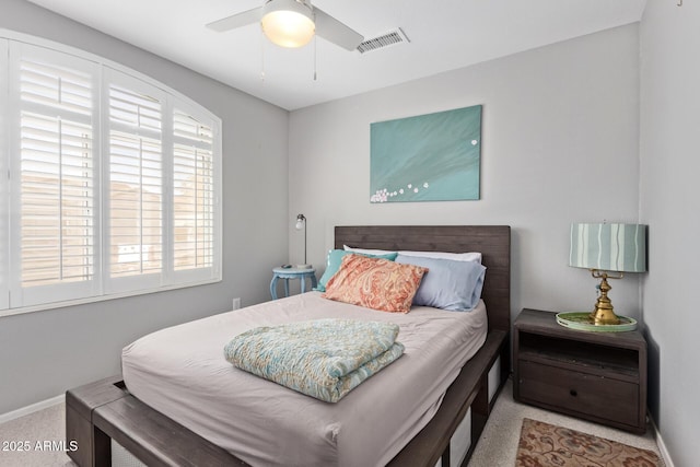 carpeted bedroom with baseboards, a ceiling fan, and visible vents