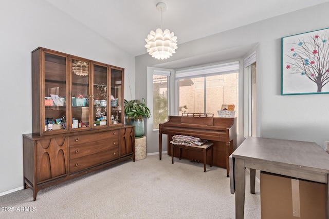 living area featuring baseboards, a chandelier, and light colored carpet
