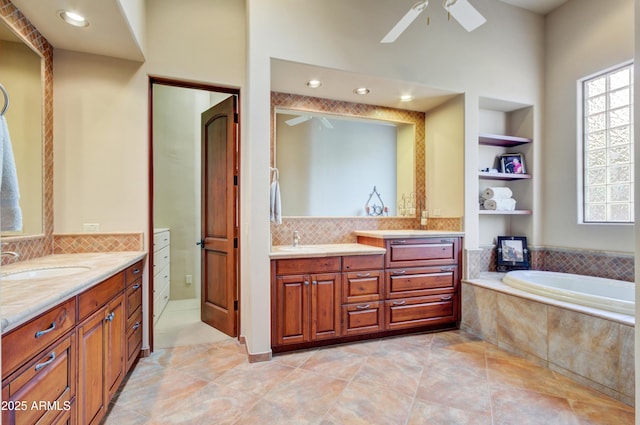 bathroom featuring ceiling fan, vanity, tiled bath, and built in features