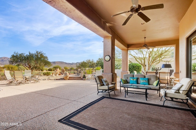 view of patio with a mountain view, outdoor lounge area, and ceiling fan