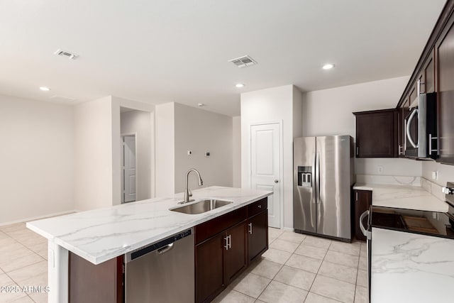 4713 W Nutmeg Ave, Coolidge, AZ 85128 - kitchen featuring stainless steel appliances, light tile patterned floors, an island with sink, light stone countertops, and recessed lighting