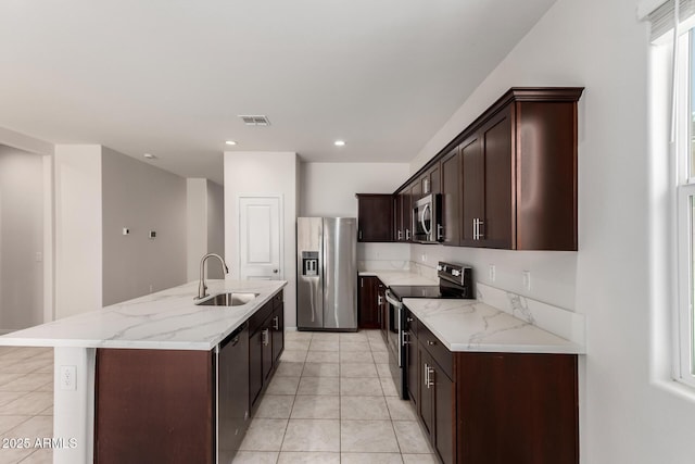 4713 W Nutmeg Ave, Coolidge, AZ 85128 - kitchen featuring appliances with stainless steel finishes, light tile patterned floors, a kitchen island with sink, light stone counters, and recessed lighting