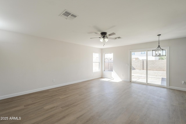 12813 W Paradise Dr, El Mirage, AZ 85335 - empty room with wood finished floors, ceiling fan, and a chandelier