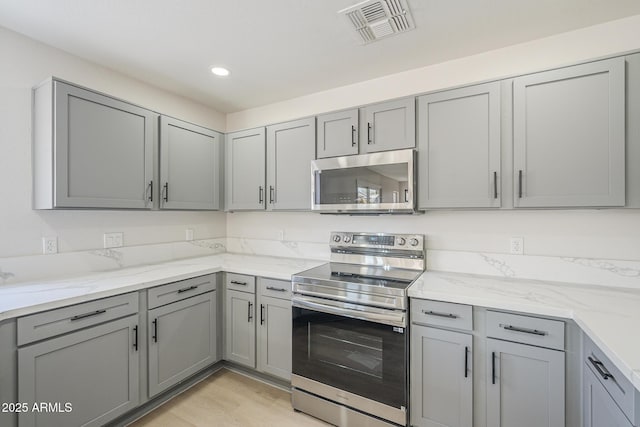 12813 W Paradise Dr, El Mirage, AZ 85335 - kitchen featuring appliances with stainless steel finishes, gray cabinetry, light stone counters, and recessed lighting