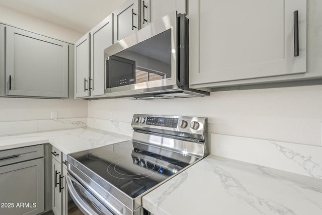 12813 W Paradise Dr, El Mirage, AZ 85335 - kitchen with appliances with stainless steel finishes, gray cabinets, and light stone counters