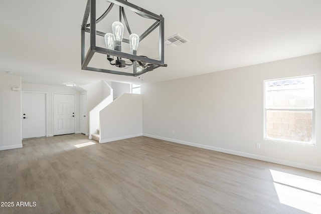 12813 W Paradise Dr, El Mirage, AZ 85335 - unfurnished living room featuring a chandelier, wood finished floors, and stairway