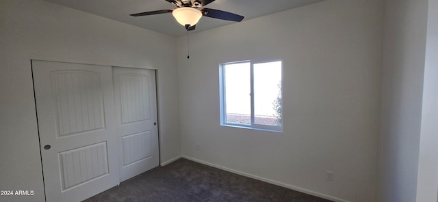 unfurnished bedroom featuring ceiling fan, a closet, and dark carpet