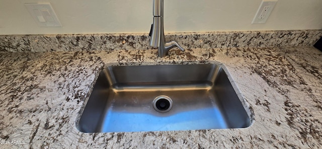 room details featuring stone countertops and sink