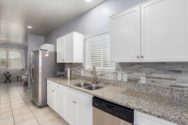 kitchen with white cabinets, appliances with stainless steel finishes, and light stone countertops