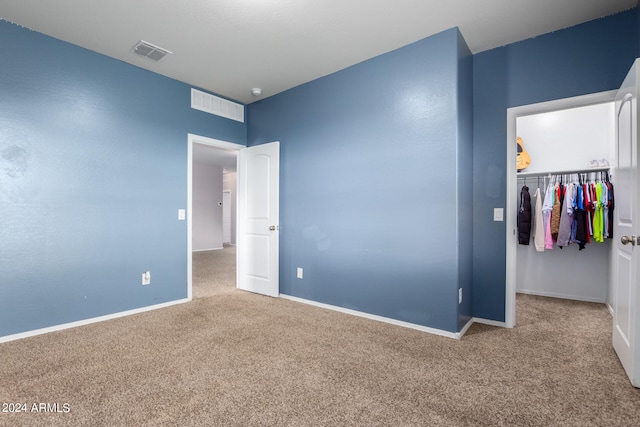 unfurnished bedroom featuring a closet and light colored carpet