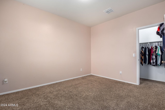 unfurnished bedroom with a closet and dark carpet