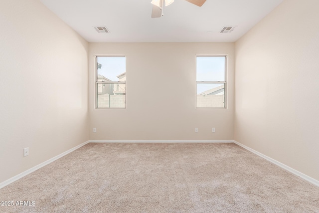 empty room with a ceiling fan, carpet, visible vents, and baseboards