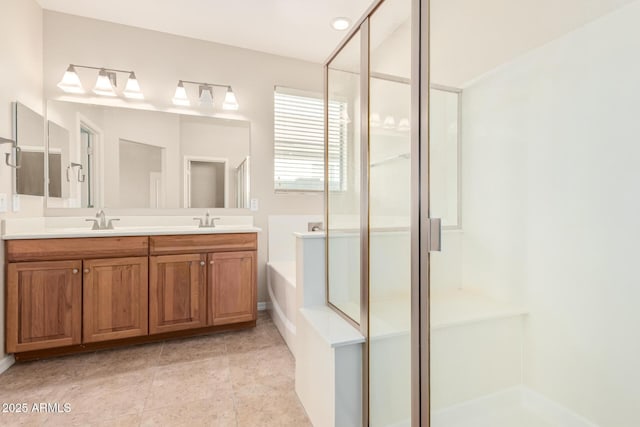 bathroom with a garden tub, double vanity, a stall shower, and a sink