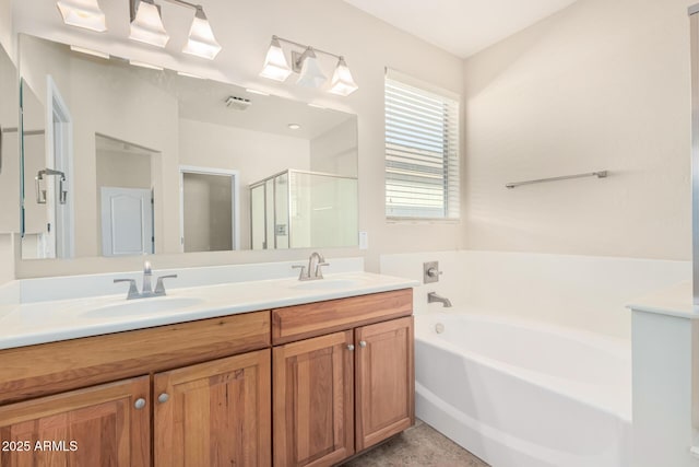 full bathroom featuring a bath, a shower stall, double vanity, and a sink