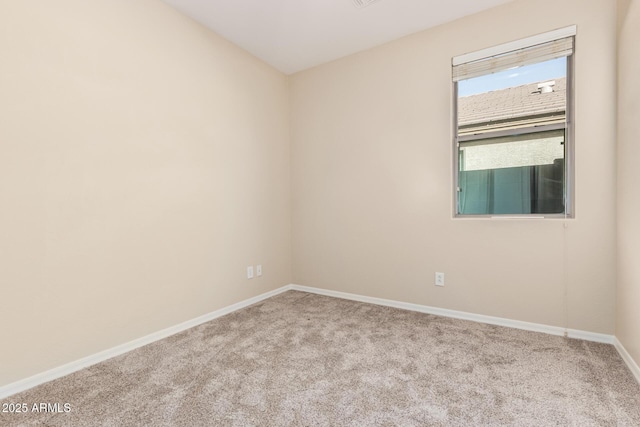 spare room featuring carpet floors and baseboards