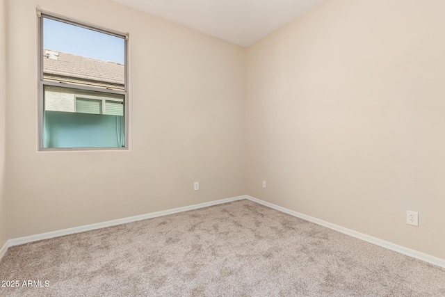 carpeted empty room featuring baseboards